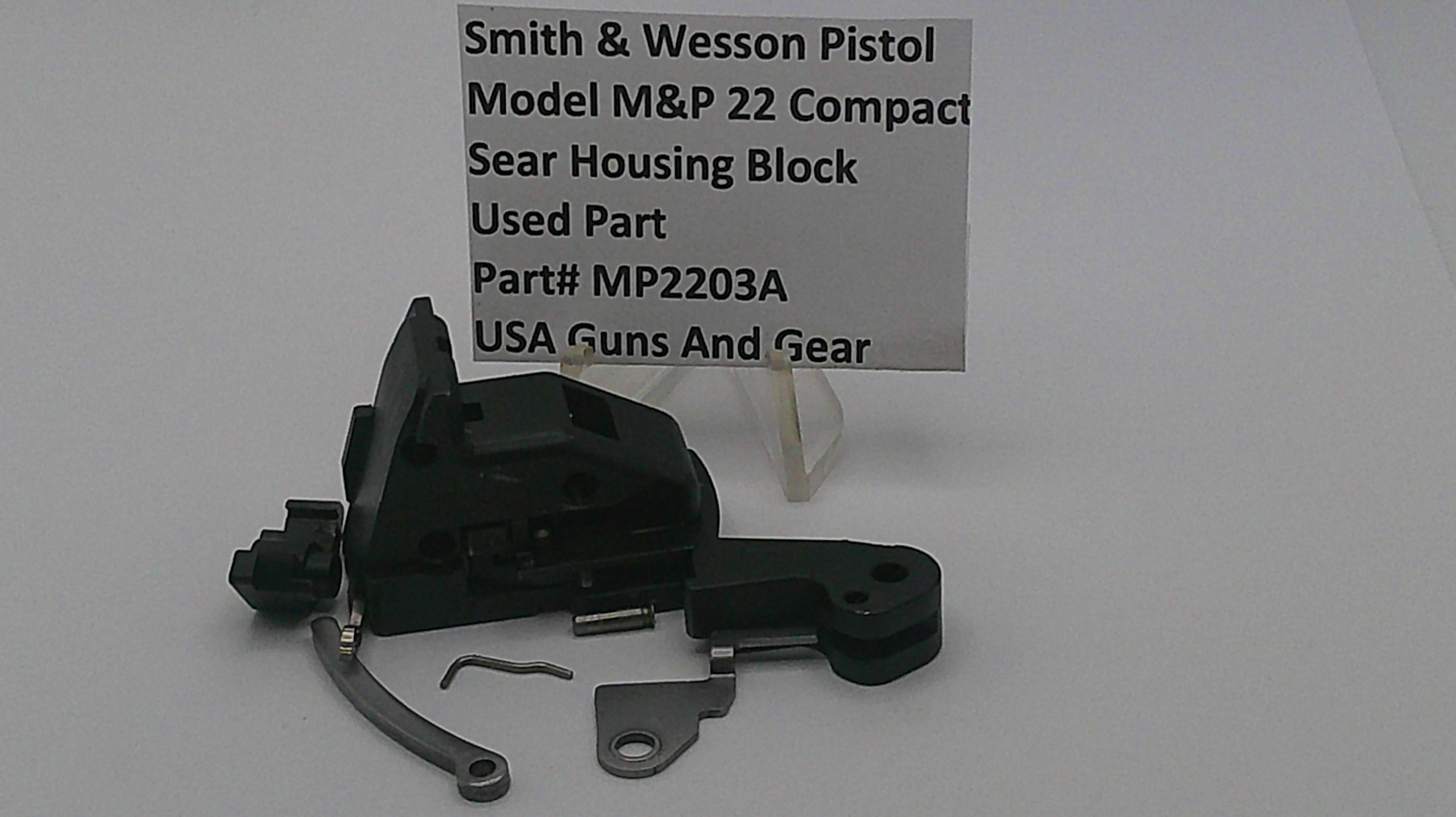 Smith & Wesson pistol part with a label on a white background