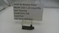Smith & Wesson pistol sear housing on a stand with a label