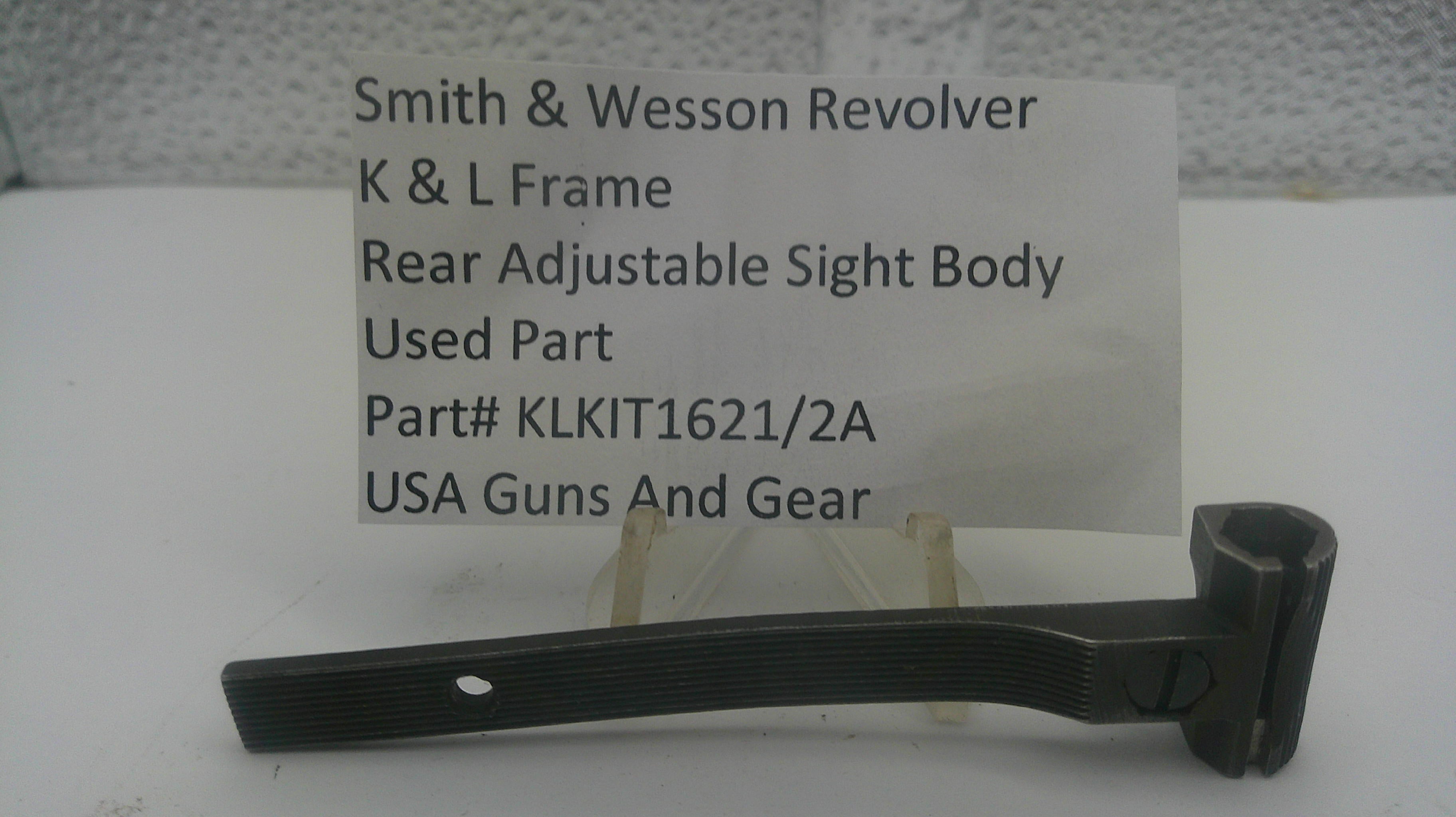 A used black metal sight body part for a Smith & Wesson revolver, displayed on a small stand in front of a white card with product details.