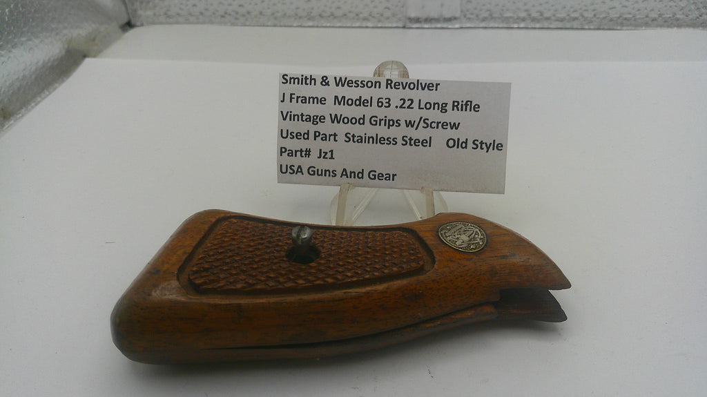 Brown gun holster with vintage wood grips and screw, on a white surface with a label.