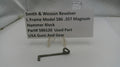 Smith & Wesson revolver hammer block part with a label on a white background