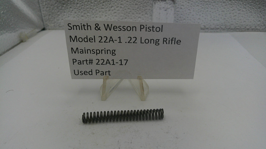 Smith & Wesson pistol mainspring with a label on a white surface