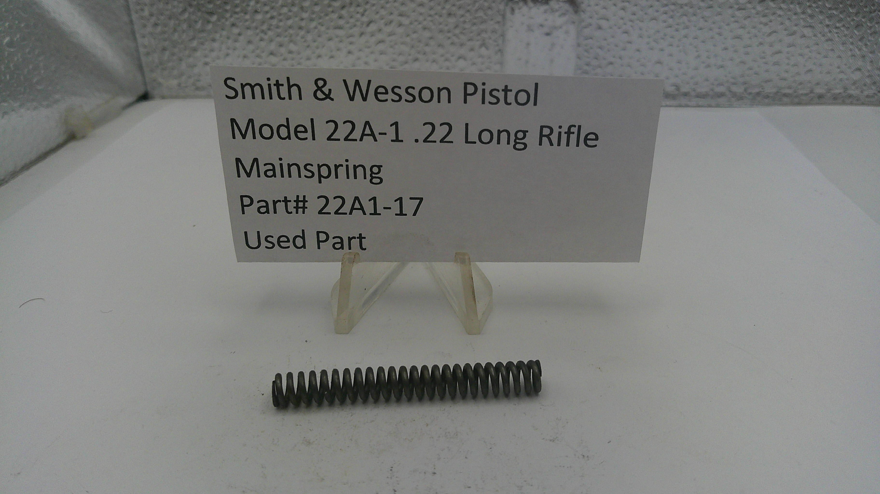 Smith & Wesson pistol mainspring with a label on a white surface