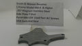 A used metal firearm part for a Smith & Wesson Revolver, displayed on a clear stand with a paper label card showing part details.