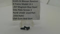Three small black metal screws displayed on a clear plastic stand in front of a white sign that reads 'Smith & Wesson Revolver K Frame Model 13-1 .357 Magnum Blue Steel Side Plate Screws 3 Part# 19160 Used Part USA Guns And Gear'.