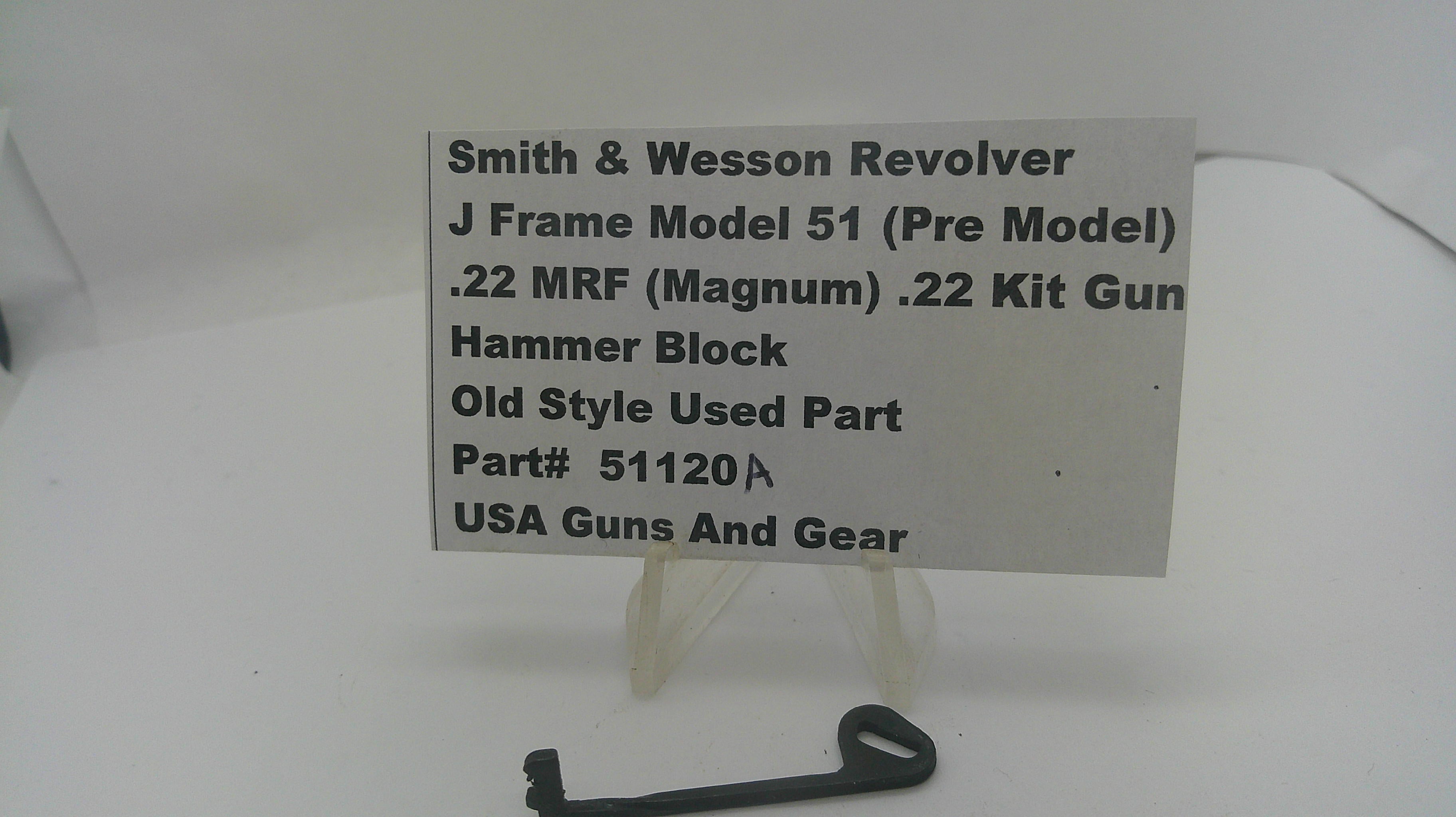 A small black metal hammer block part displayed on a clear stand in front of a white sign that reads 'Smith & Wesson Revolver J Frame Model 51 (Pre Model) .22 MRF (Magnum) .
