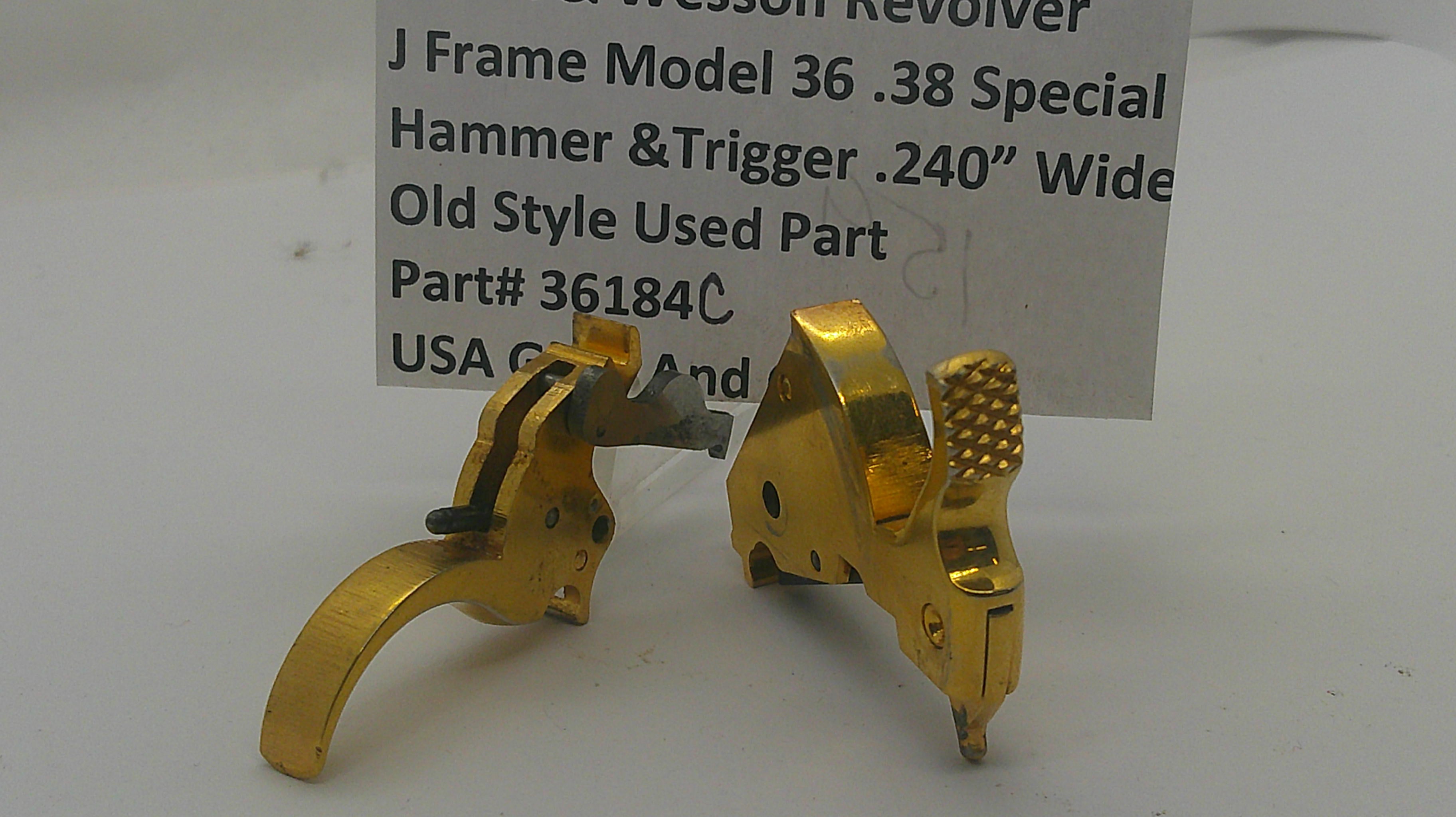 A pair of gold-colored metal hammer and trigger components for a J Frame Model 36 revolver, displayed on a white surface with a product information card in the background.