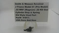 A small black metal cylinder stop and spring part displayed below a white sign that reads 'Smith & Wesson Revolver J Frame Model 51 (.22 MRF .