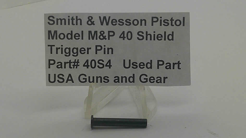 A small black metal trigger pin displayed below a gray sign that reads 'Smith & Wesson Pistol Model M&P 40 Shield Trigger Pin Part# 40S4 Used Part USA Guns and Gear' on a plain light background.