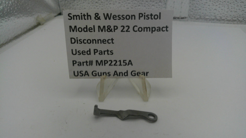 Used parts of a Smith & Wesson pistol on a white surface with a label.