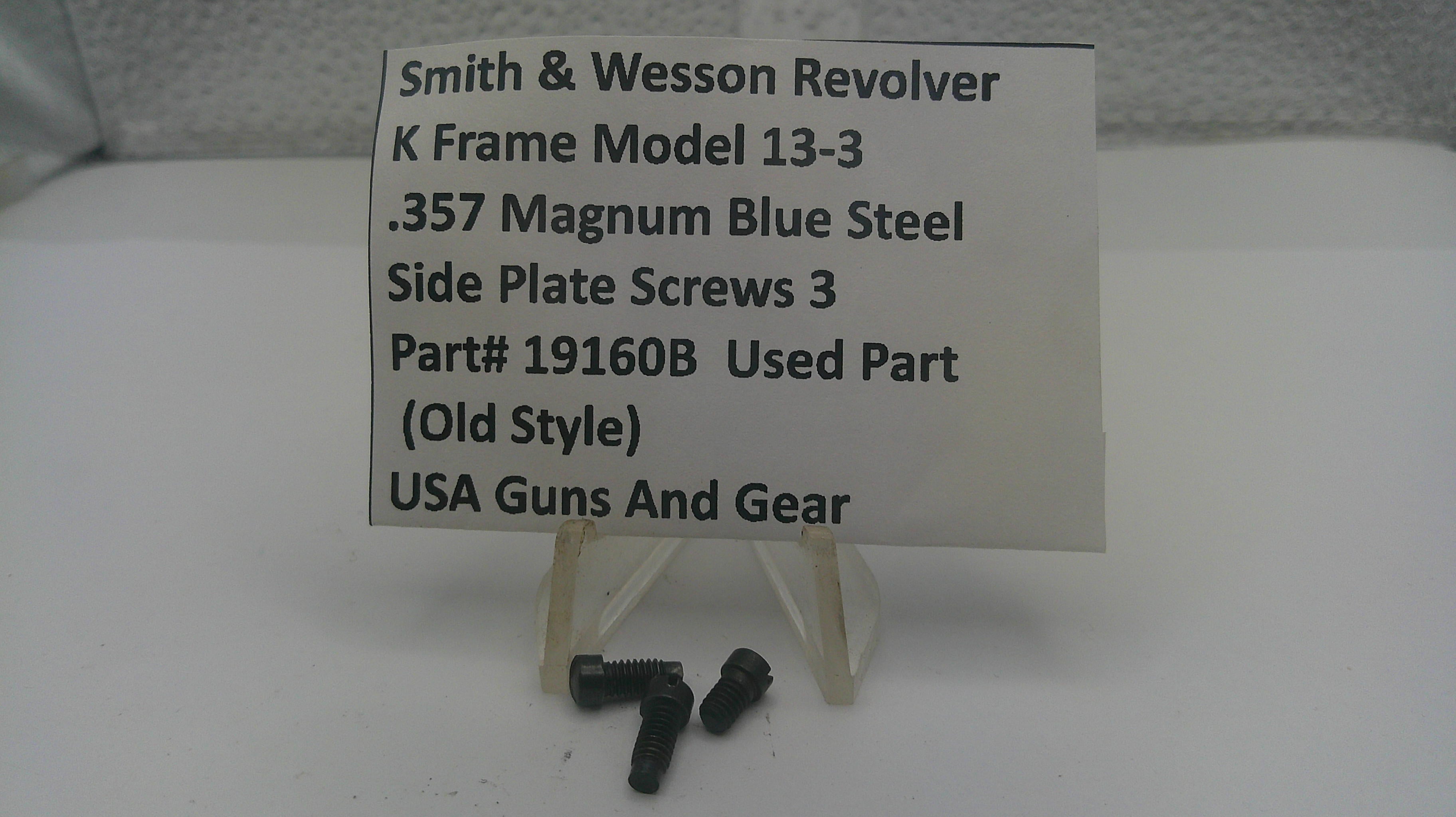 Three small black metal screws displayed in front of a white sign that reads 'Smith & Wesson Revolver K Frame Model 13-3 .357 Magnum Blue Steel Side Plate Screws 3 Part# 19160B Used Part (Old Style) USA Guns And Gear' on a small clear stand.