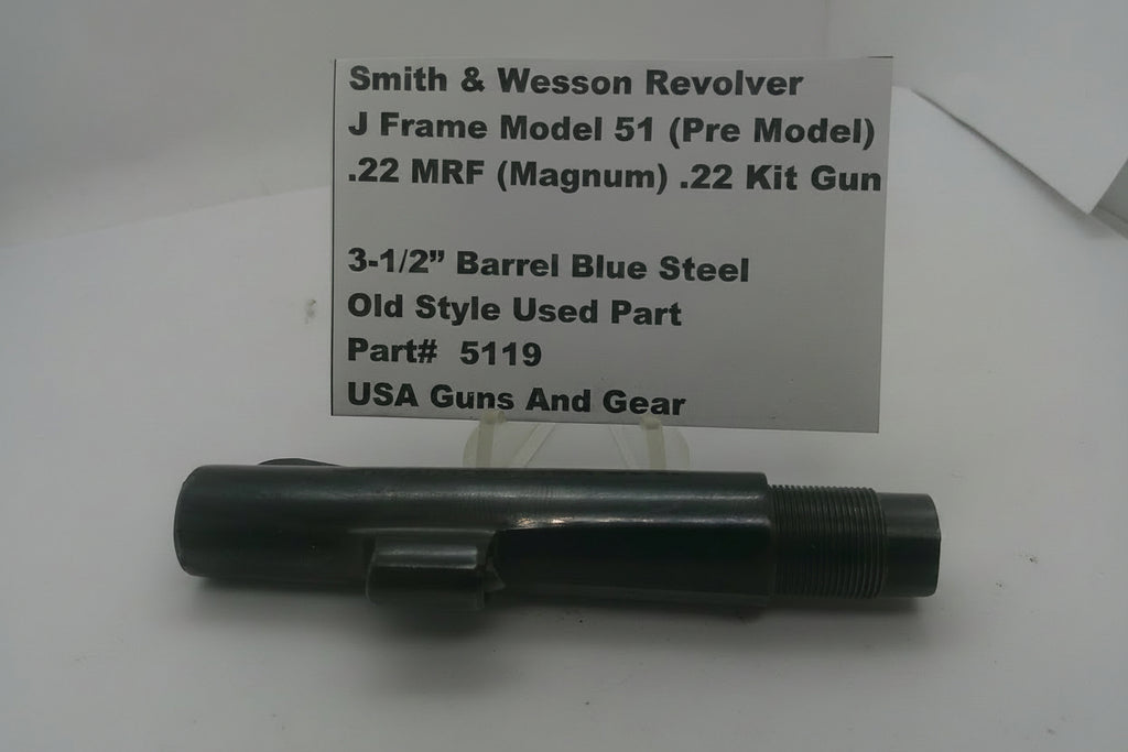 A black metal Smith & Wesson revolver, displayed on a white surface with a paper label card behind it containing product details.