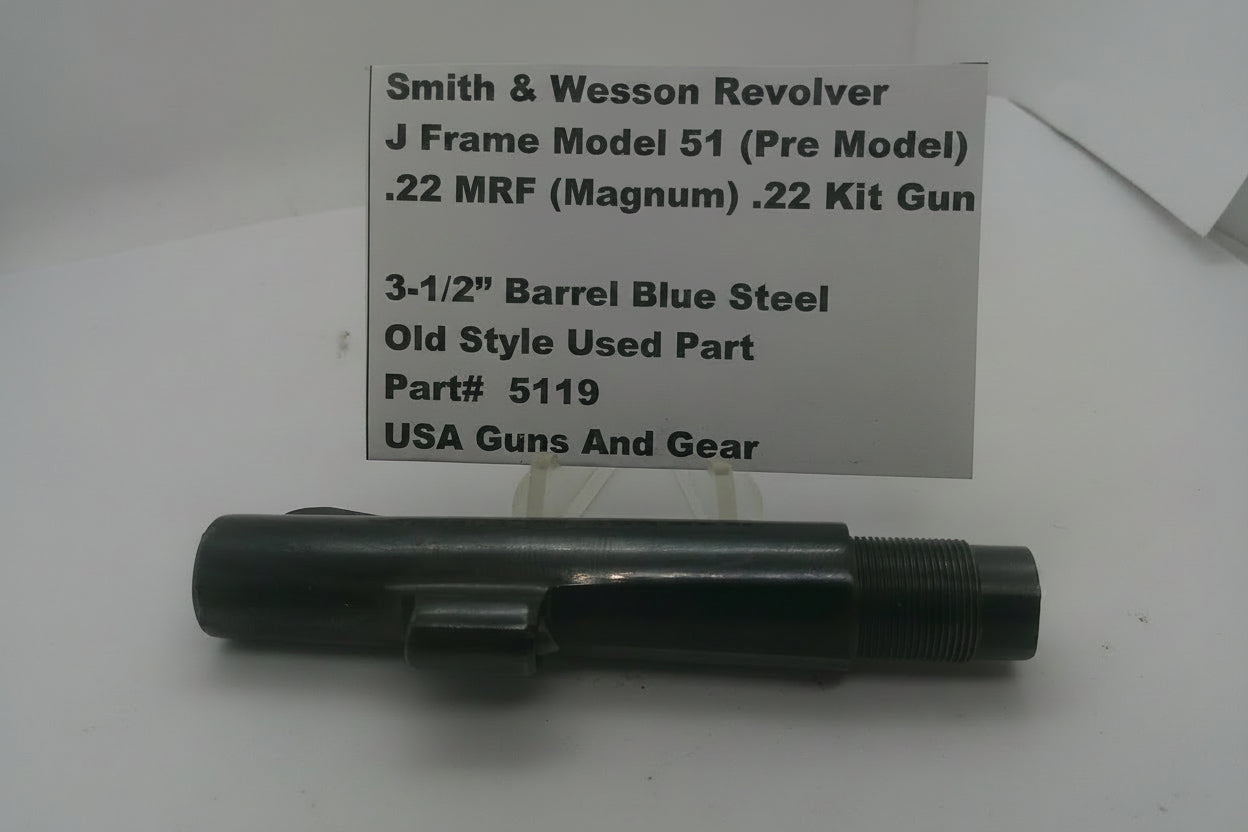 A black metal Smith & Wesson revolver, displayed on a white surface with a paper label card behind it containing product details.