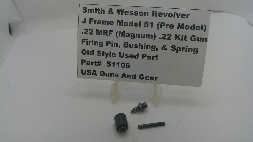 A used metal part set for a Smith & Wesson revolver, displayed on a white surface with a white label card. The parts include a black cylindrical component and two small dark metal pins.