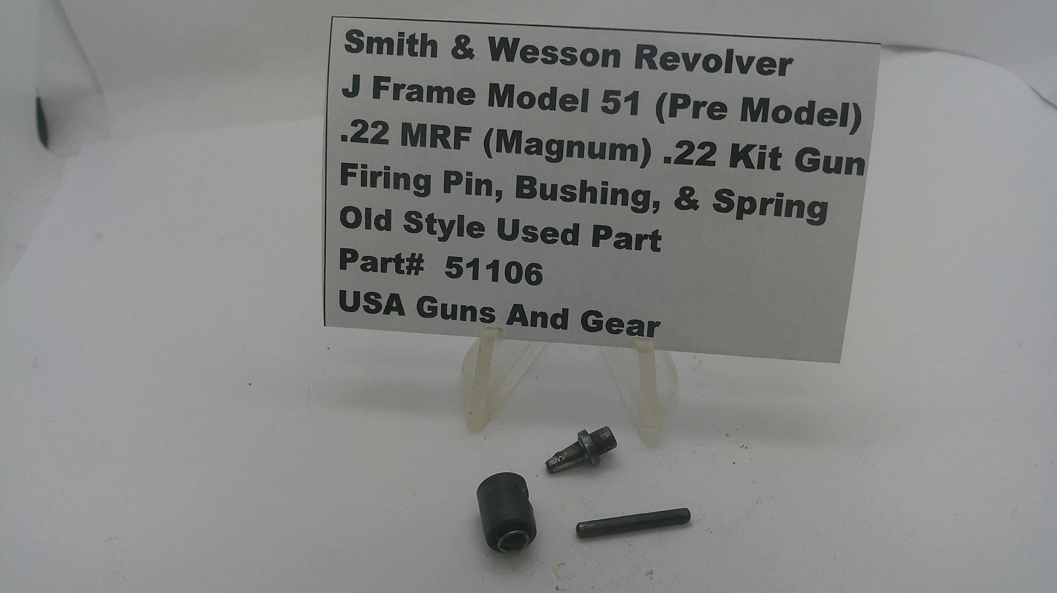 A used metal part set for a Smith & Wesson revolver, displayed on a white surface with a white label card. The parts include a black cylindrical component and two small dark metal pins.