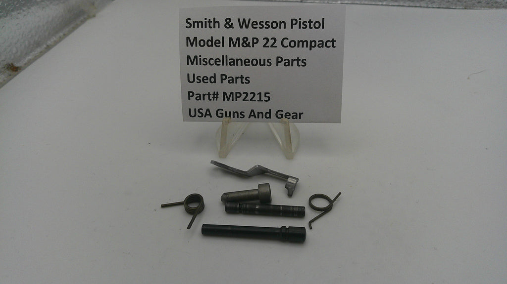 Smith & Wesson pistol parts on a white surface with a label.