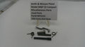 Smith & Wesson pistol parts on a white surface with a label.