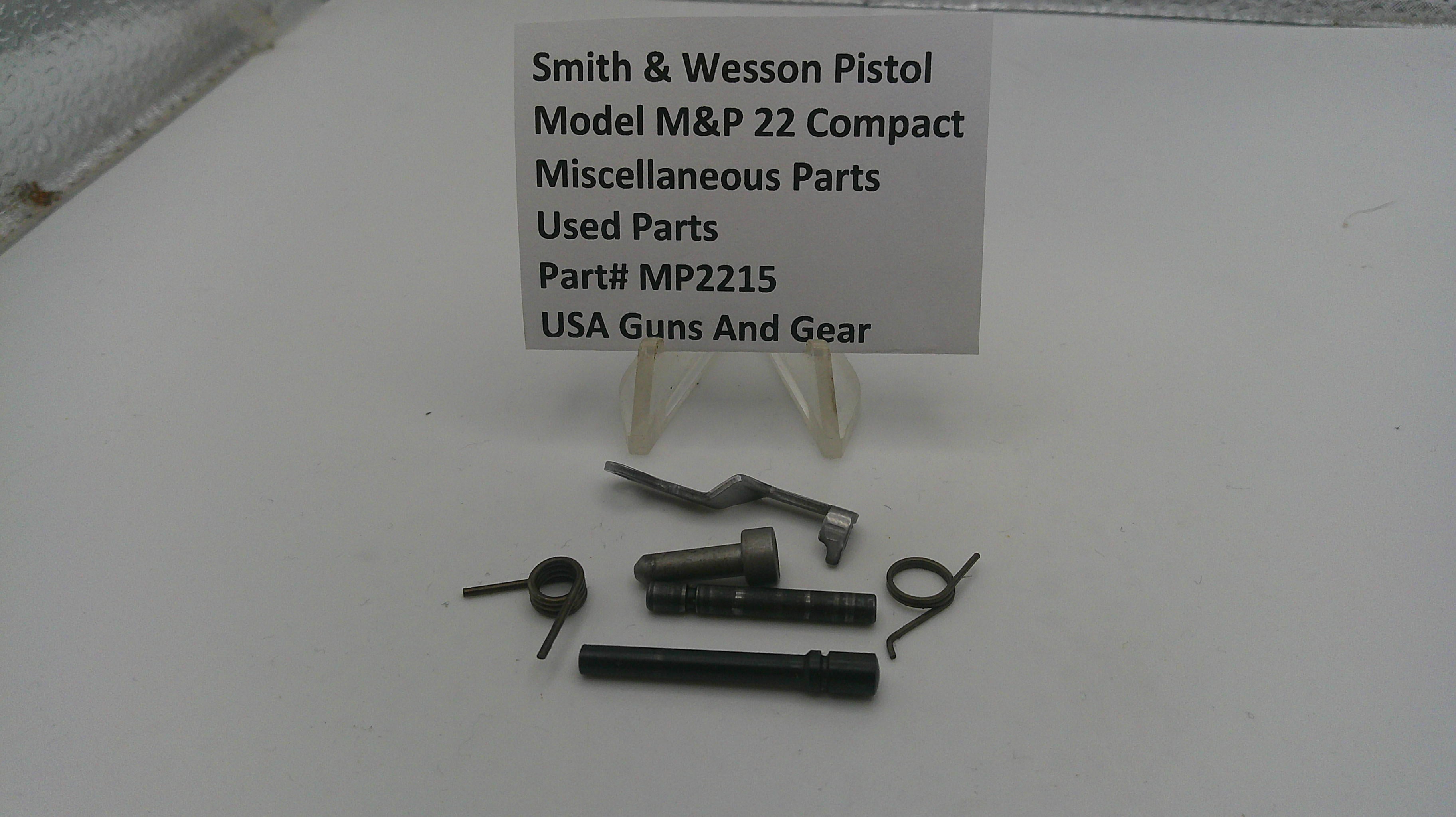 Smith & Wesson pistol parts on a white surface with a label.