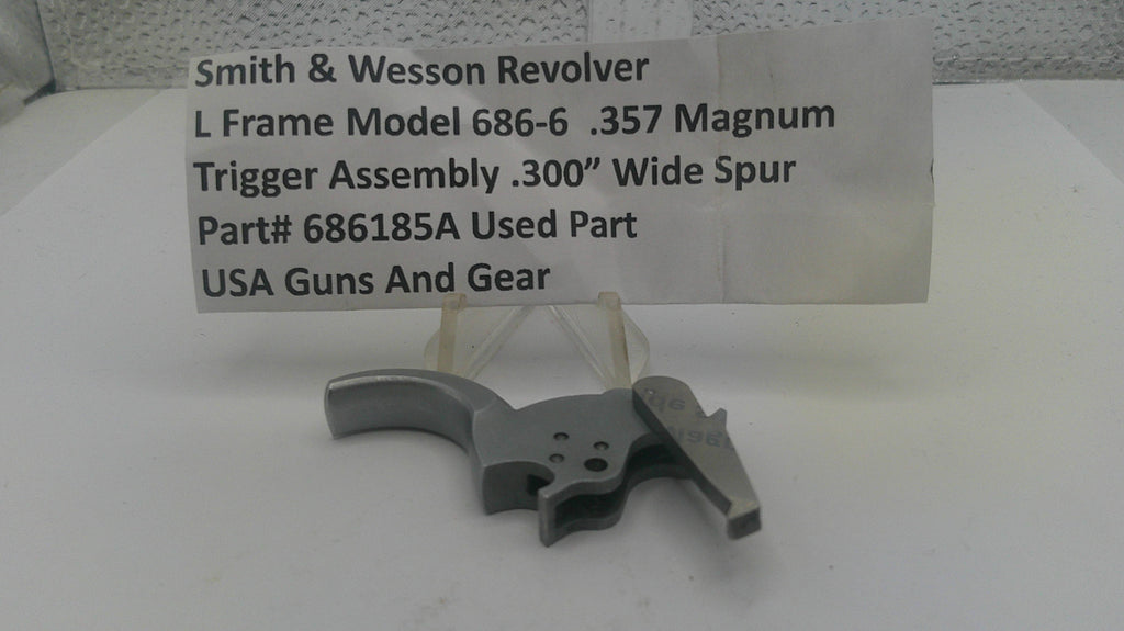Smith & Wesson Revolver trigger assembly on a white surface with a label.