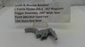 Smith & Wesson Revolver trigger assembly on a white surface with a label.