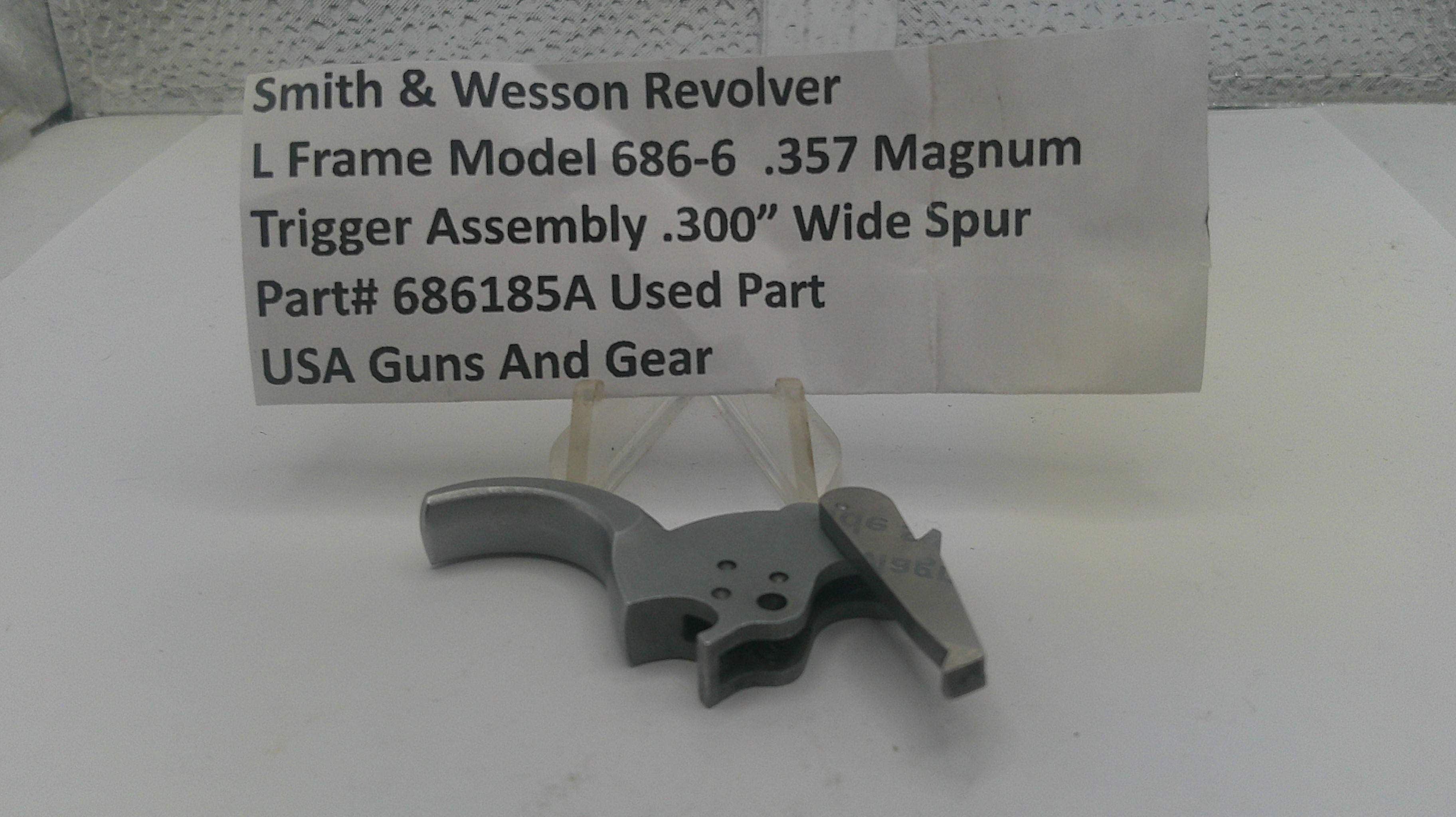 Smith & Wesson Revolver trigger assembly on a white surface with a label.
