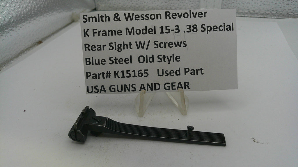 Smith & Wesson revolver rear sight with screws on a white background, accompanied by a label.
