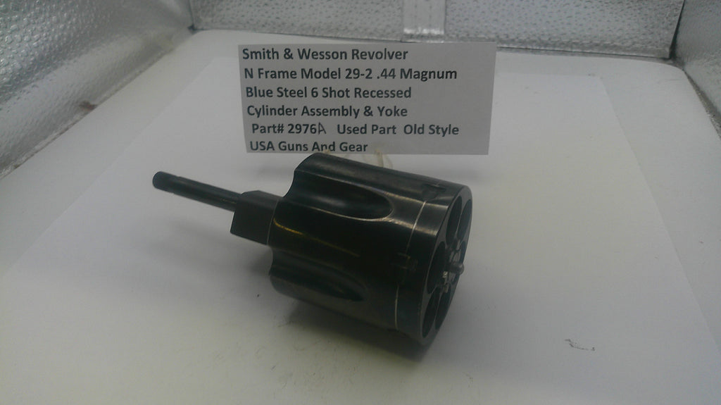 Smith & Wesson revolver cylinder assembly on a white surface with a label.