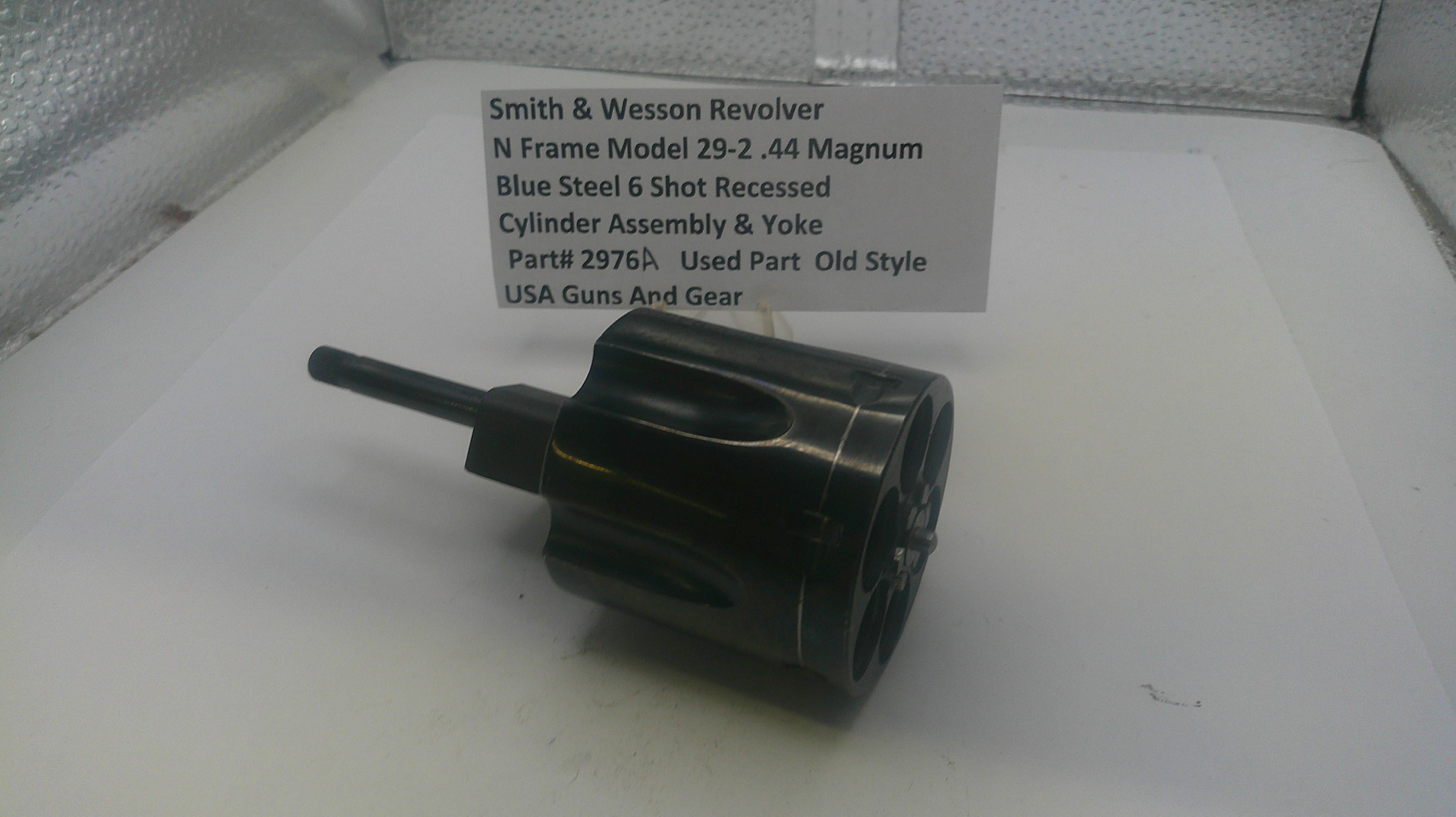 Smith & Wesson revolver cylinder assembly on a white surface with a label.