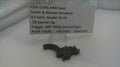 Smith & Wesson Revolver trigger part on a white surface with a label