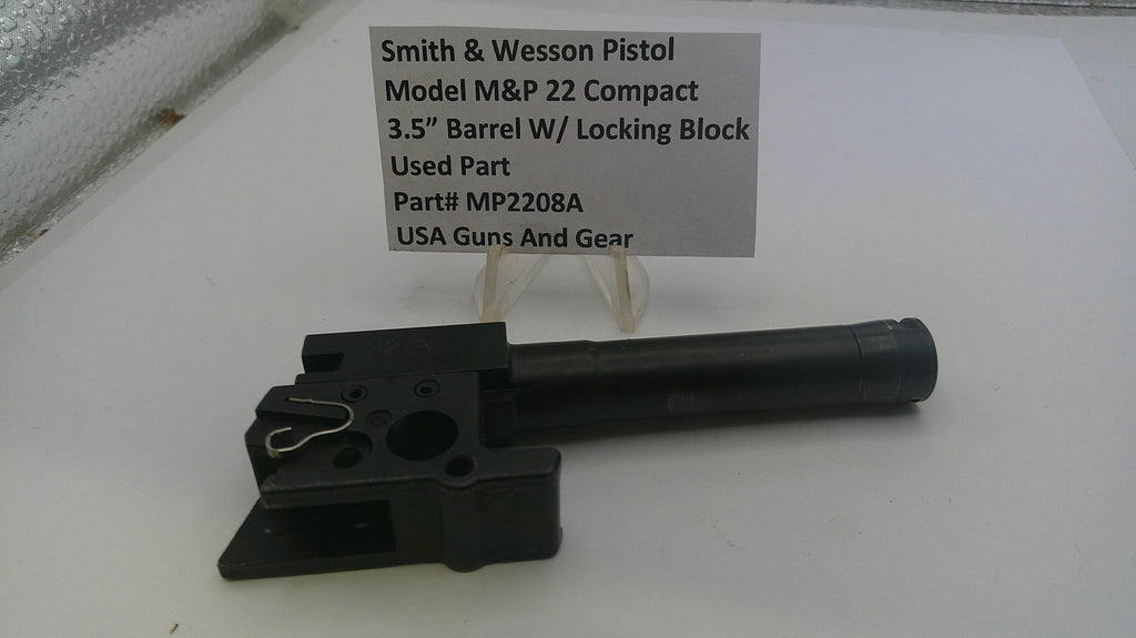 Smith & Wesson pistol part on a white surface with a label