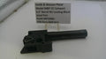 Smith & Wesson pistol part on a white surface with a label
