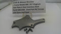 Smith & Wesson revolver side plate with screws on a white background, accompanied by a label.