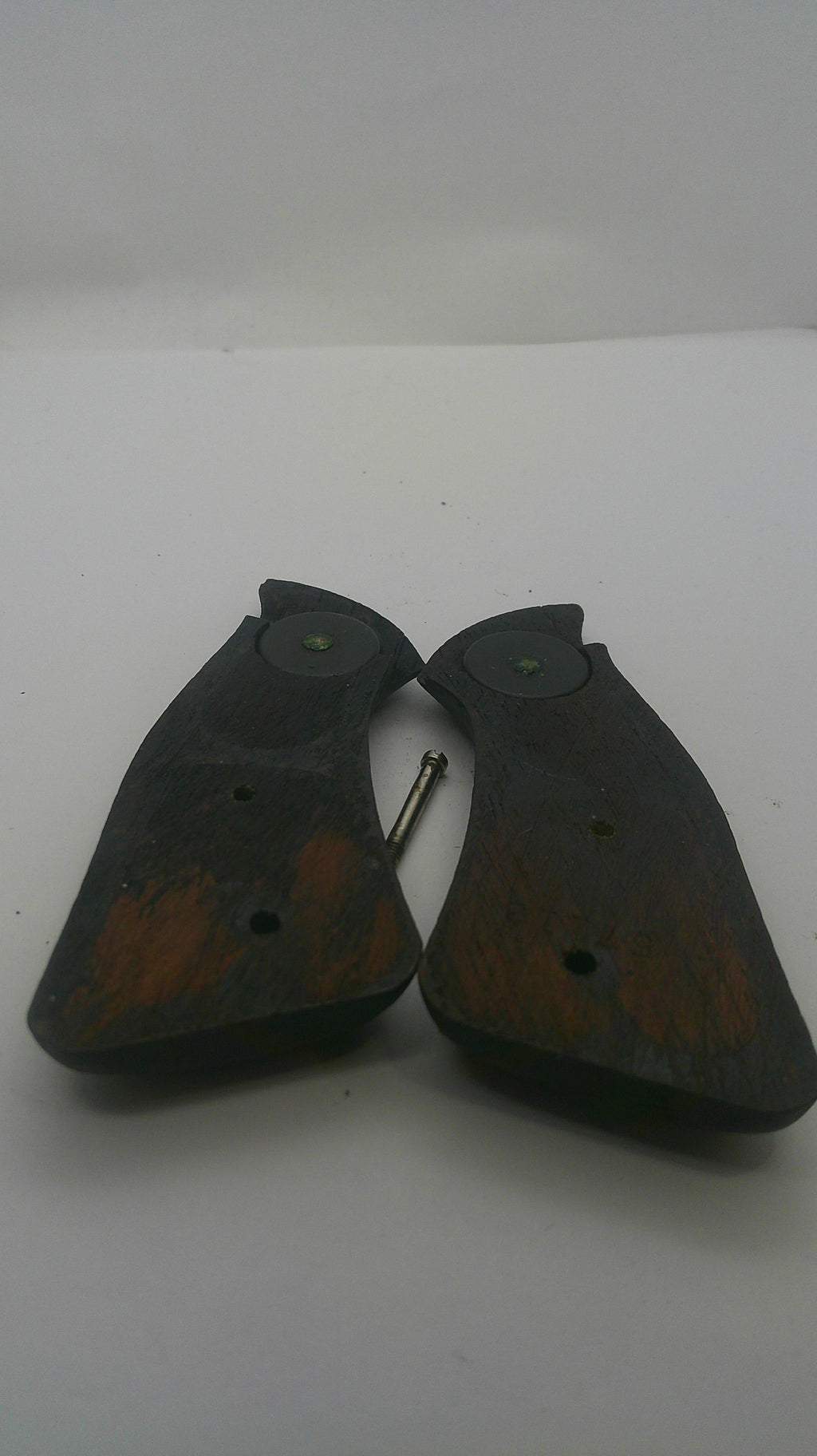 A pair of dark brown wooden shoe pull tabs with metal hooks, shown on a plain white background.
