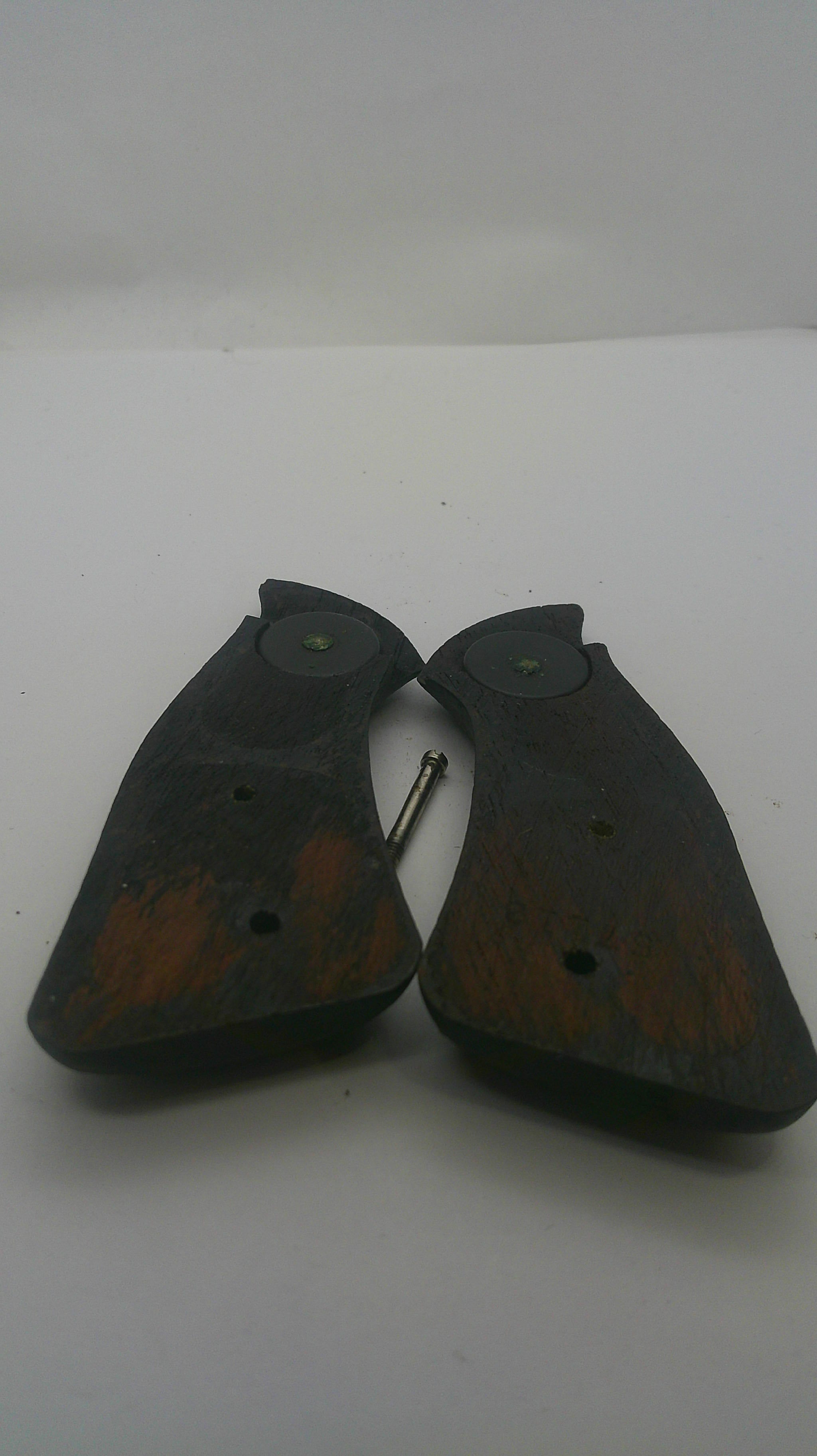 A pair of dark brown wooden shoe pull tabs with metal hooks, shown on a plain white background.