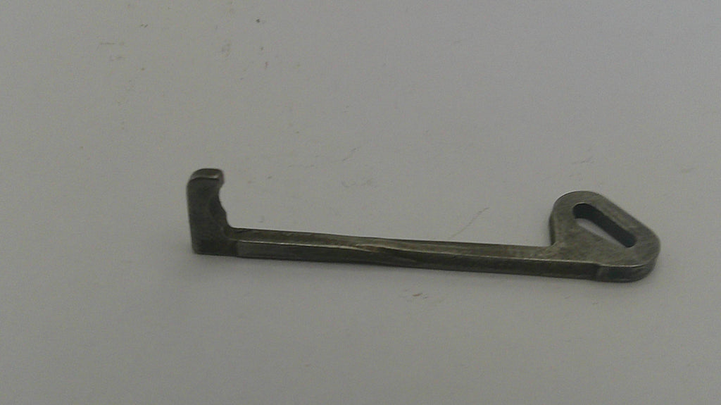 Metallic key-like object on a light gray background