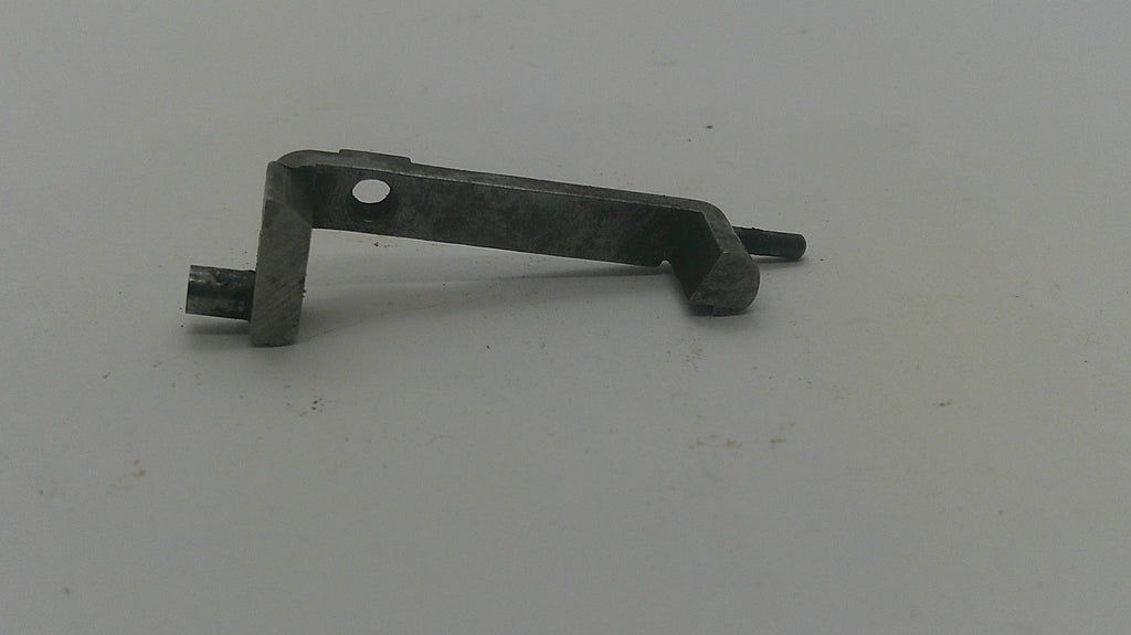 A small dark metal hardware piece with a circular hole and a protruding pin, photographed on a plain light background.
