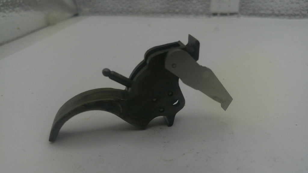Black metal tool with a blade on a white surface