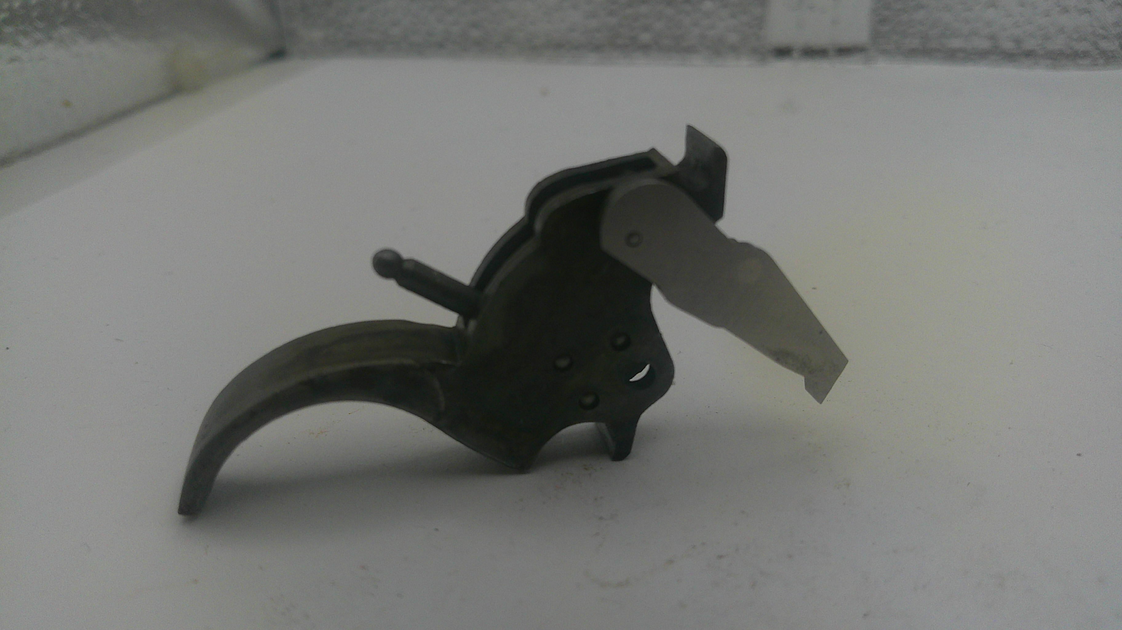 Black metal tool with a blade on a white surface