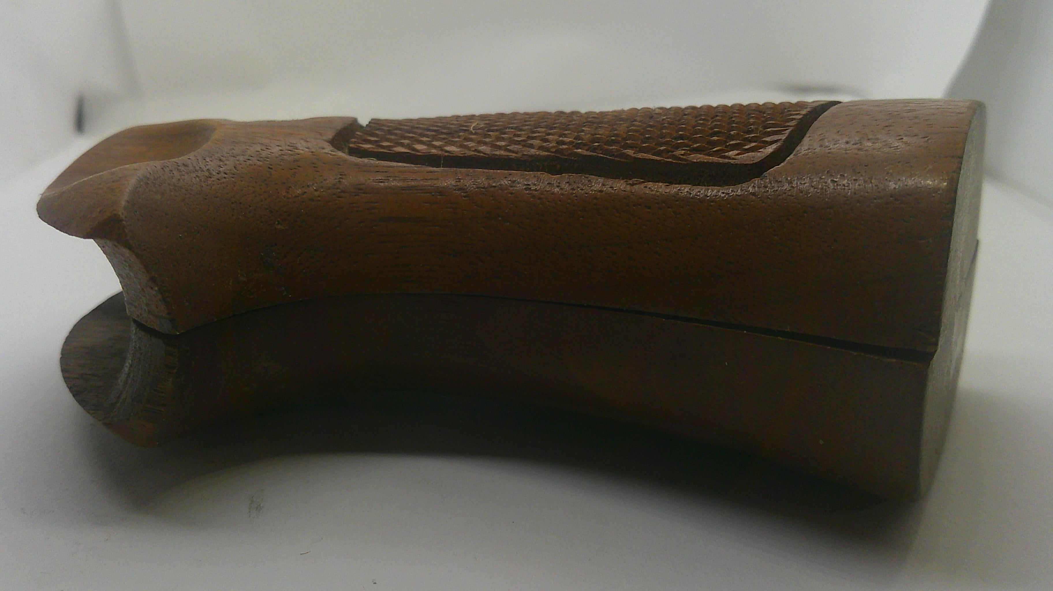 A brown wooden gunstock grip with a textured grip panel and a darker wood base, shown on a plain white background.