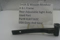 A used black metal part for a Smith & Wesson revolver rear adjustable sight body, displayed on a clear stand with a white label card showing part details.
