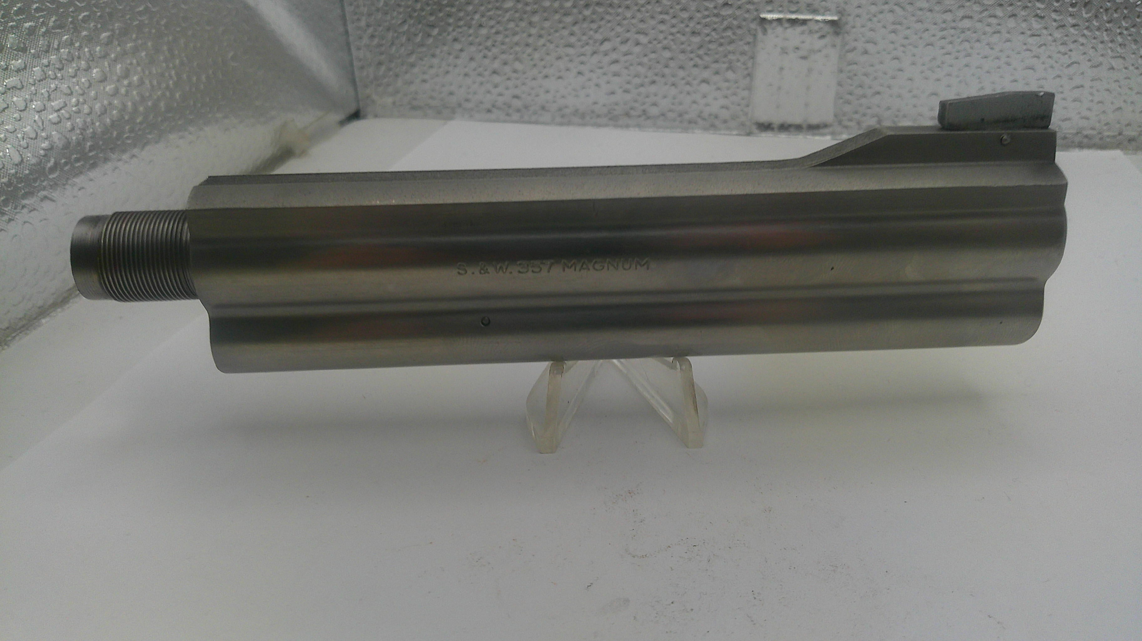 Metal tool or component on a stand against a textured wall background