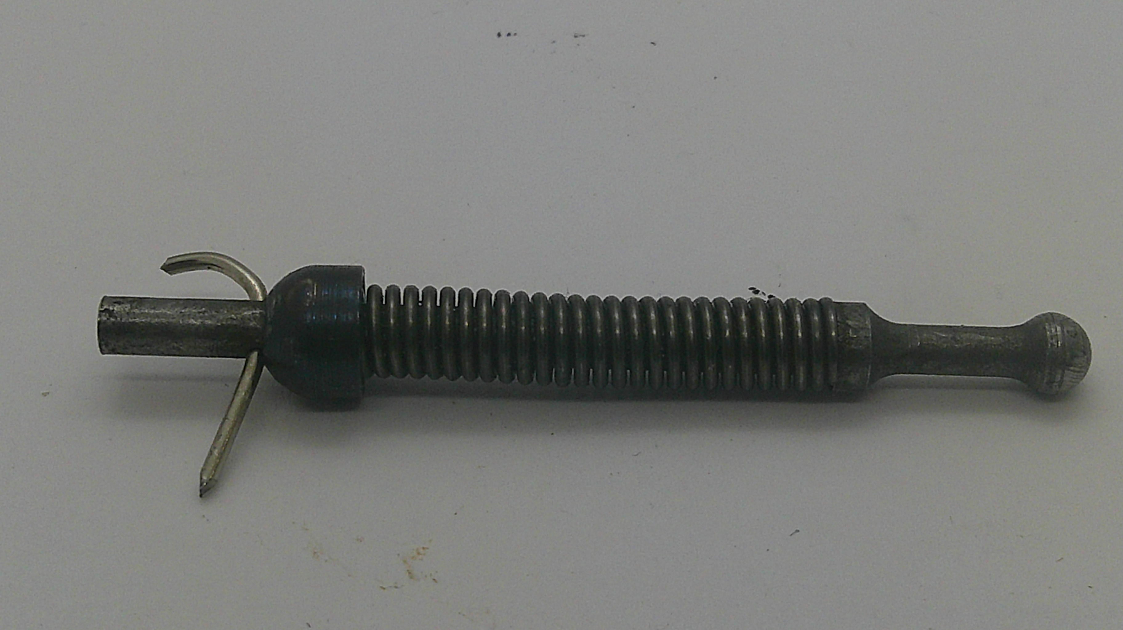 A vintage metal tool or hardware piece with a threaded barrel, a curved hook-like end, and a small pin, shown on a plain off-white background.
