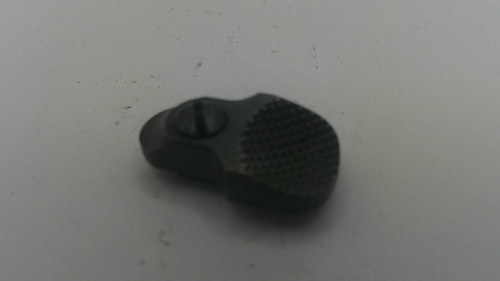 A small black textured plastic or rubber component with a central screw, photographed on a plain light gray surface.