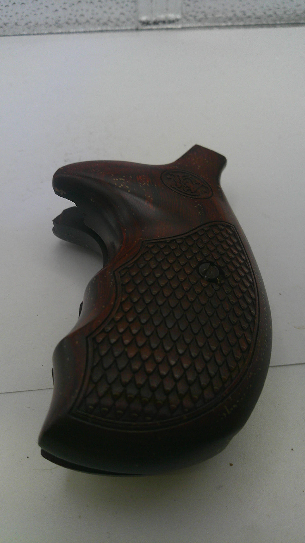 Brown leather saddle on a white floor