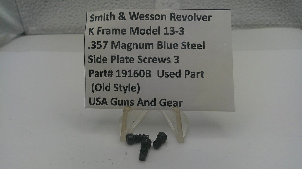 Three small black metal screws displayed below a white sign that reads 'Smith & Wesson Revolver K Frame Model 13-3 .357 Magnum Blue Steel Side Plate Screws 3 Part# 19160B Used Part (Old Style) USA Guns And Gear' on a white stand.
