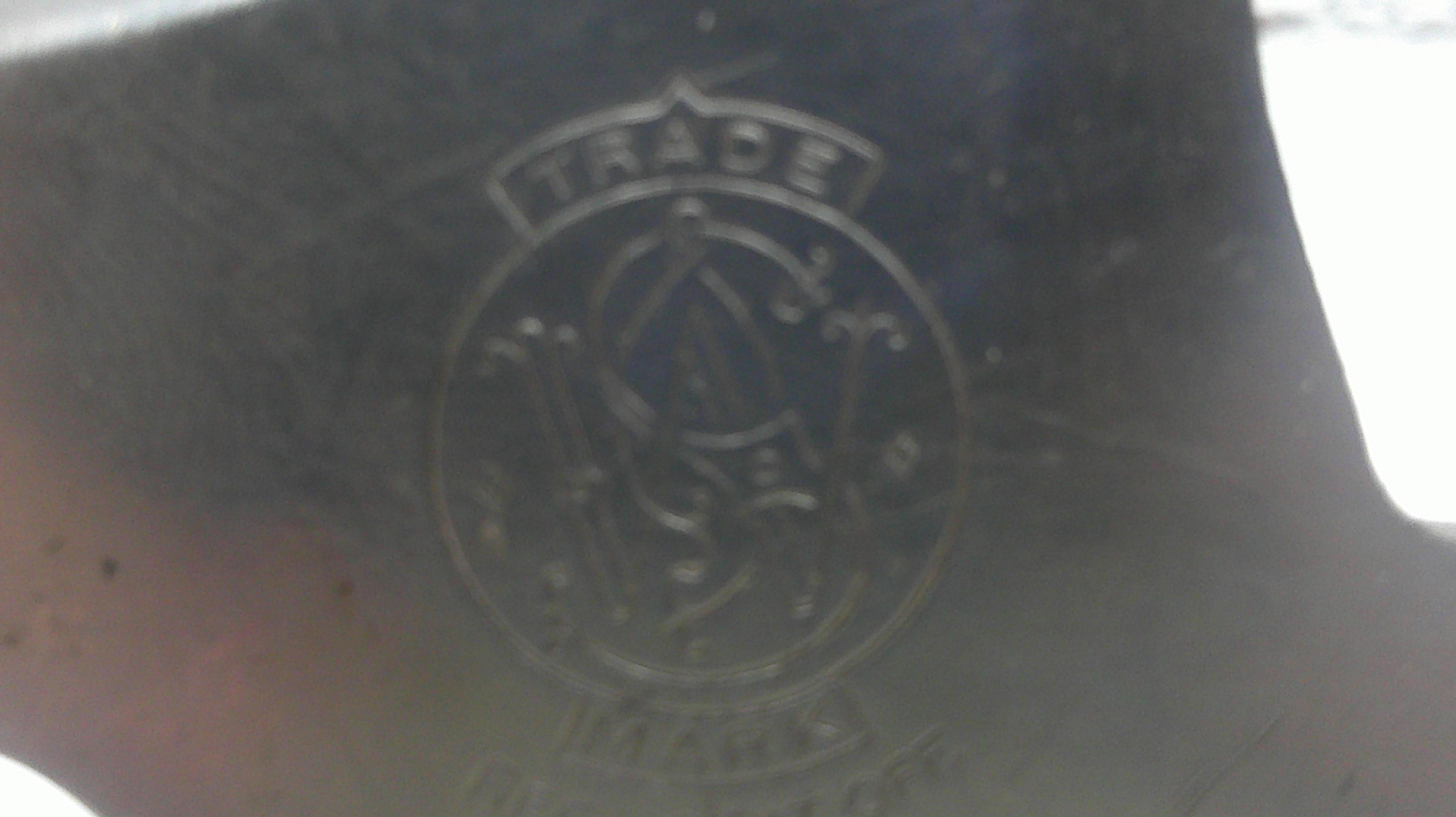 Close-up of a black surface with an embossed logo and text.