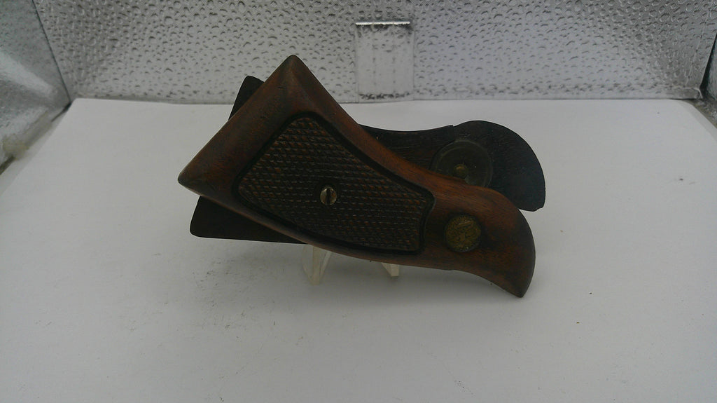 Brown leather boot jack on a white surface with a textured wall in the background