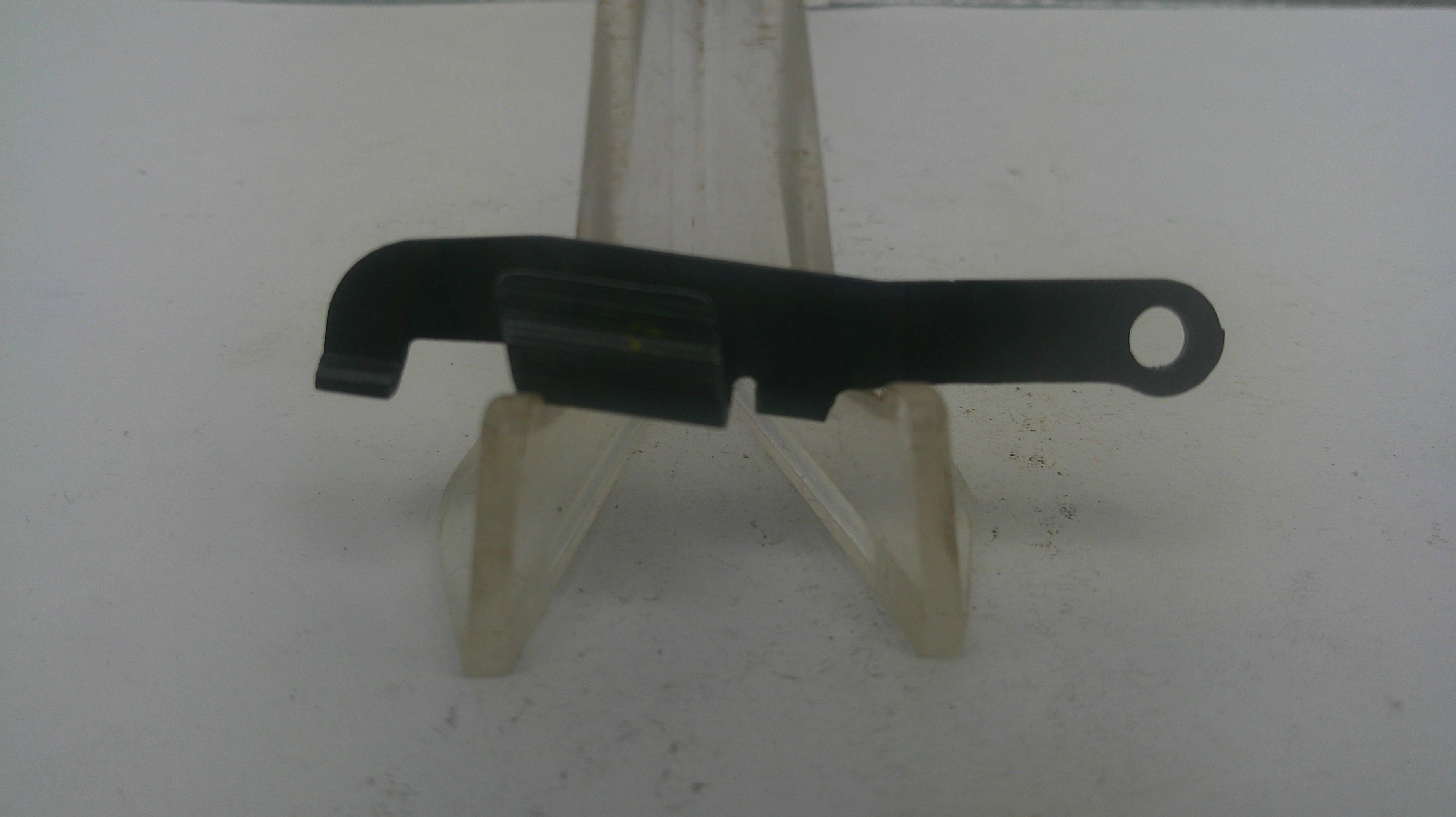 A small black plastic or metal tool component with a looped end, displayed on a clear plastic stand against a plain light background.