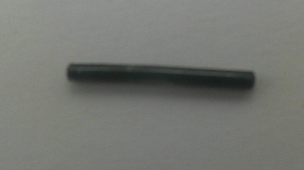 A small, dark metallic cylindrical rod or pin lying horizontally on a plain light gray background.