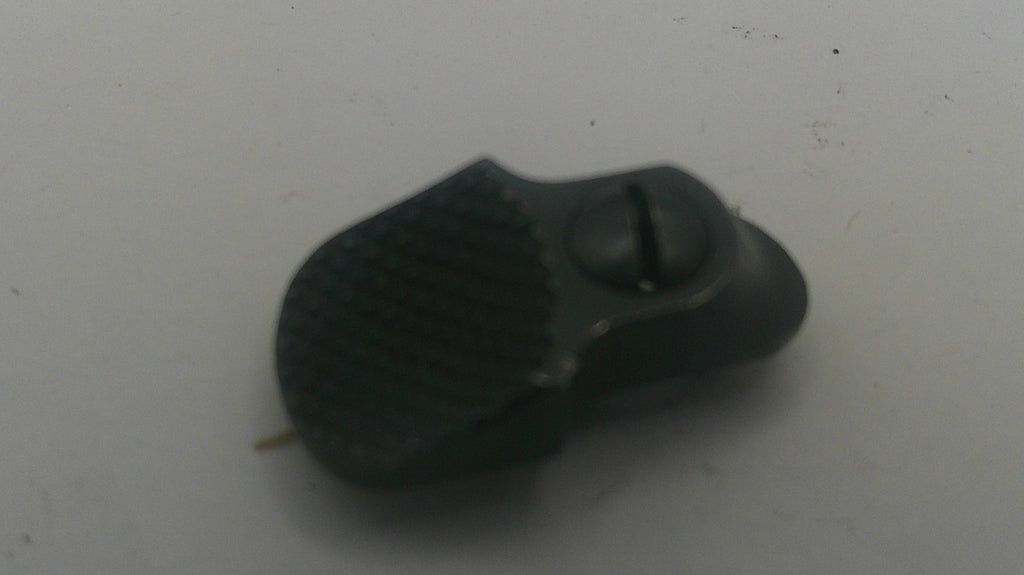 A small black textured plastic component with a screw, photographed on a plain light gray surface.